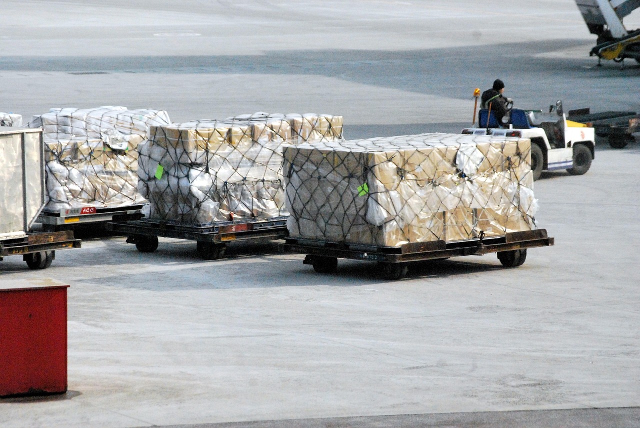 Paleți de marfă ambalați și pregătiți pentru livrare într-un hub logistic, ilustrând fluxul de comenzi EDI dintre furnizor și retailer